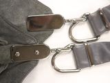 two metal buckles on a black bag on a white surface