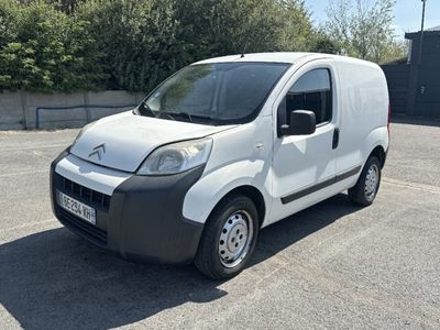 une petite camionnette blanche garée dans un parking