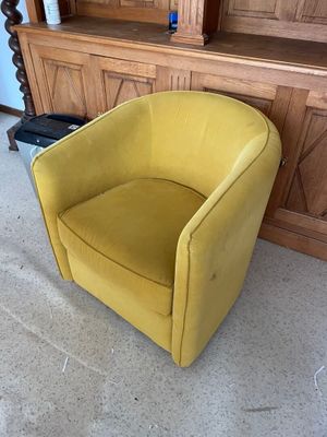 yellow chair in front of a wooden entertainment center in a living room