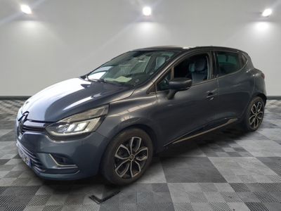 une voiture grise est garée dans une pièce au sol à carreaux