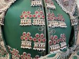 an image of a green dress with red and white beads