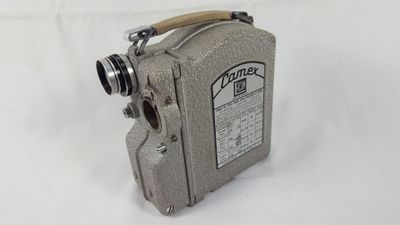 un vieux projecteur de cinéma posé sur une surface blanche