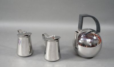 deux pichets en argent et une théière posés sur une table