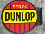 a red and yellow sign that says stock dunlop on the side of a building