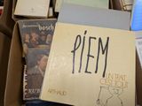 une pile de livres dans un carton sur lequel est accrochée une étiquette