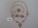 une photo d'un ensemble composé d'un collier et de boucles d'oreilles, avec une étiquette de prix