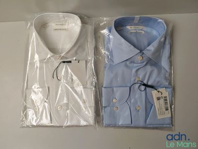 two men ' s shirts in plastic bags sitting on a table