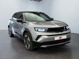 the front view of a silver suv parked in a showroom