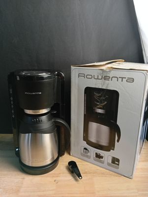 une cafetière posée à côté d'une boîte sur une table