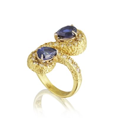 a close up of a gold ring with two blue stones