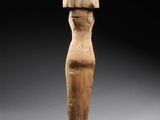 a wooden statue of a woman standing on a wooden base