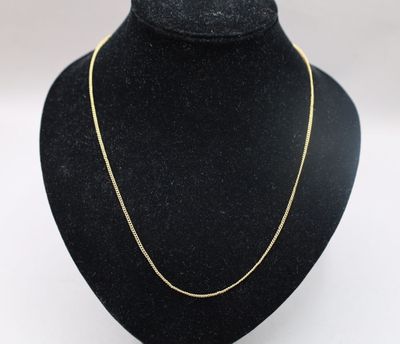 a gold chain necklace on a mannequin neck