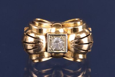 bague en or jaune ornée d'un diamant au centre et d'un nœud autour de l'anneau