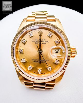 a gold rolex watch with diamonds on the dial