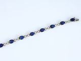 a close up of a bracelet with blue beads on a white background