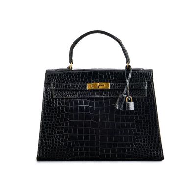 a black crocodile skin handbag on a white background