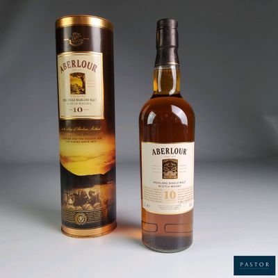 a close up of a bottle of whisky next to a cardboard box