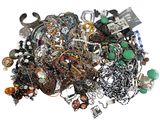 a pile of assorted jewelry on a white surface