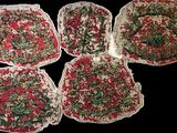 quatre morceaux de tissu ornés de motifs rouges et verts sont posés sur une surface noire