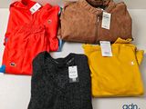 Quatre pulls de couleurs différentes sont exposés dans une boîte