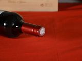 a bottle of wine sitting on a red table cloth