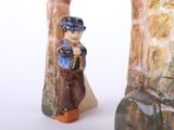 two figurines of a man and a woman standing next to each other