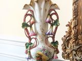 un vase posé sur une table à côté d'un miroir