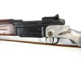 an old gun with a wooden handle on a white surface
