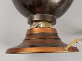 a metal lamp that is on top of a wooden stand