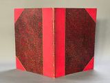 a red book with a red cover sitting on top of a table