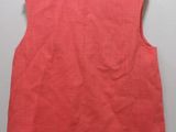 a red vest on a hanger against a white wall