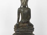 une statue en bronze représentant un Bouddha assis sur un socle