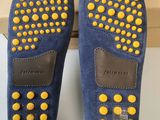 a pair of blue sued shoes with yellow studded soles