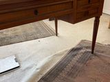 a desk with a glass top on a rug in a living room