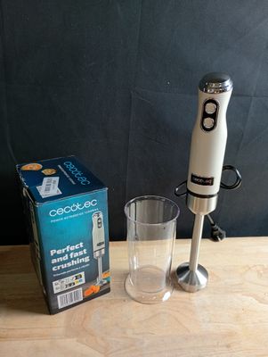 un mixeur posé sur une table à côté d'un verre