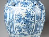 an old blue and white vase with a bird on top of it