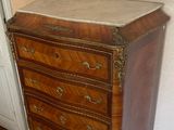 a wooden chest of drawers with a marble top