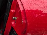 a red car with its door open on a rainy day