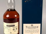 a bottle of whisky sitting next to a box on a table