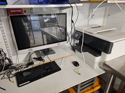 a desk with a computer and a printer on it
