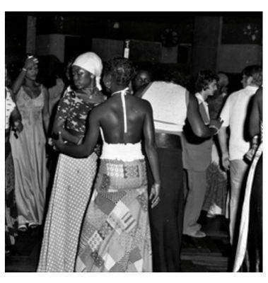 a black and white photo of a couple dancing at a party