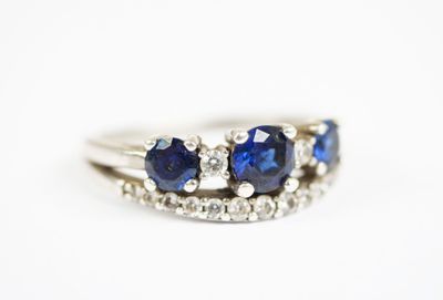 un gros plan d'une bague en or blanc sertie de saphirs bleus et de diamants