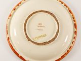 a white plate with a brown rim on a white table