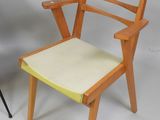 a wooden chair with a yellow seat next to a black chair