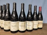 several bottles of wine are lined up on a wooden table