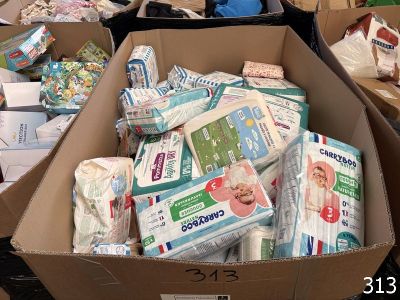 Des boîtes de couches et de lingettes sont empilées sur un carton