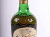 une vieille bouteille de whisky posée sur une surface blanche