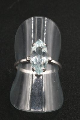 a close up of a silver ring with a blue topaz stone
