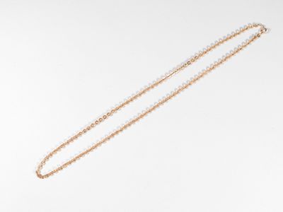 gros plan d'un collier avec une chaîne en or sur fond blanc