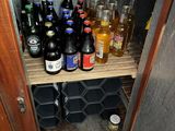 many bottles of beer on the shelves in the cabinet